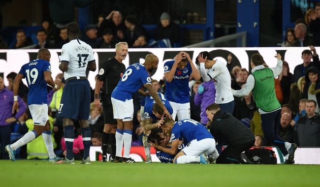 Teammates comfort Everton's Portuguese midfielder André Gomes (C floor) as he gets attention for an injury during the English Premier League football match between Everton and Tottenham Hotspur at Goodison Park in Liverpool, north west England on November 3, 2019. (Photo by Oli SCARFF / AFP) / RESTRICTED TO EDITORIAL USE. No use with unauthorized audio, video, data, fixture lists, club/league logos or 'live' services. Online in-match use limited to 120 images. An additional 40 images may be used in extra time. No video emulation. Social media in-match use limited to 120 images. An additional 40 images may be used in extra time. No use in betting publications, games or single club/league/player publications. /  (Photo by OLI SCARFF/AFP via Getty Images)