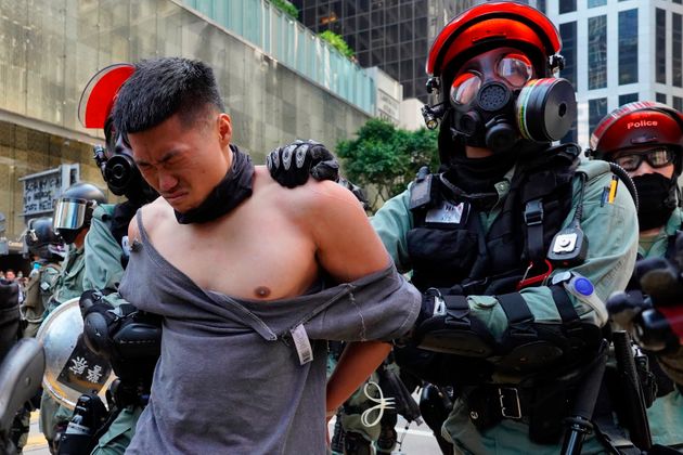 A protester is detained in Central district of Hong Kong on Monday, Nov. 11, 2019. A Hong Kong protester was shot by police Monday in a dramatic scene caught on video as demonstrators blocked train lines and roads during the morning commute. (AP Photo/Vincent Yu)