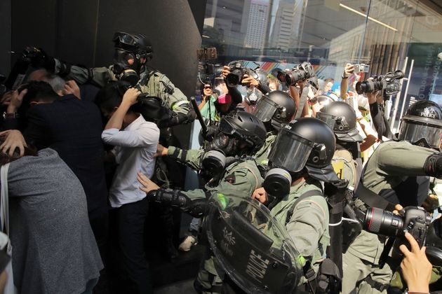 Riot police push a crowd to clear the area in Hong Kong on Monday, Nov. 11, 2019. A protester was shot by police Monday in a dramatic scene caught on video as demonstrators blocked train lines and roads during the morning commute. (AP Photo/Kin Cheung)