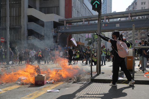 Protesters burn debris to block a road in Hong Kong on Monday, Nov. 11, 2019. Police in Hong Kong shot a protester as demonstrators blocked subway lines and roads during the Monday morning commute. (AP Photo/Kin Cheung)