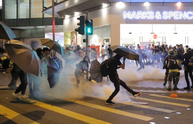 A protestor kicks away a police teargas shell as they clash outside a shopping mall in Hong Kong, Sunday, Nov. 10, 2019. Protesters smashed windows in a subway station and a shopping mall Sunday and police made arrests in areas across Hong Kong amid anger over a demonstrator's death and the arrest of pro-democracy lawmakers.Hong Kong is in the sixth month of protests that began in June over a proposed extradition law and have expanded to include demands for greater democracy and other grievances. (AP Photo/Kin Cheung)