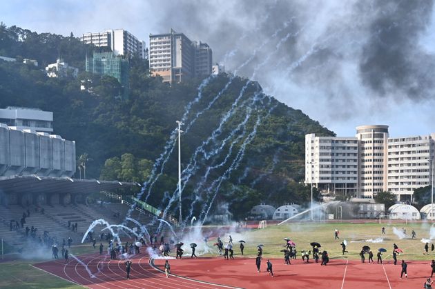 Protesters react after police fired tear gas at the Chinese University of Hong Kong (CUHK), in Hong Kong on November 12, 2019. - Hong Kong protesters struck the city's transport network for a second day running on November 12 as western powers voiced concern over spiralling violence after police shot a young demonstrator and another man was set on fire. (Photo by Philip FONG / AFP) (Photo by PHILIP FONG/AFP via Getty Images)