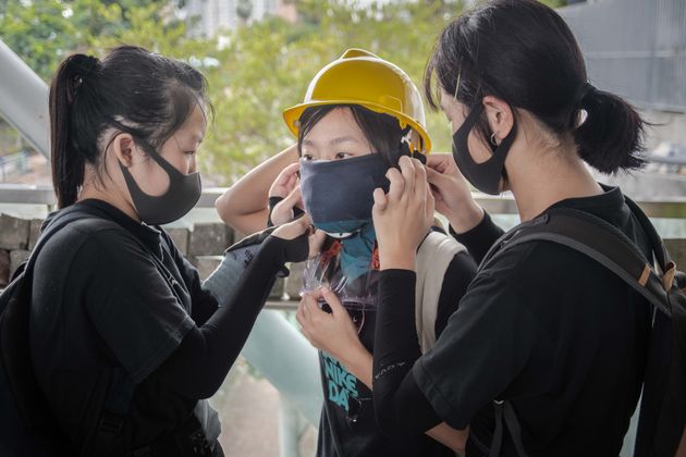 KOWLOON TONG, HONG KONG, CHINA - 2019/11/12: Protesters help another protester to put a face mask during the demonstration.
Protesters called for a day of strike and commuters faced chaos and delays across Hong Kong for the second consecutive day as anti-government protesters blocked roads, train rails and subway accesses on a call for strike. Unrest broke out at three universities and many schools and businesses were closed. Violence returned in a response to police actions on Monday when at least two protesters were shot and many others wounded. (Photo by Ivan Abreu/SOPA Images/LightRocket via Getty Images)