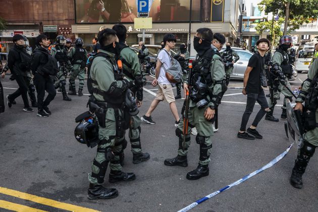 People are detained by police near the Hong Kong Polytechnic University in Hung Hom district of Hong Kong on November 18, 2019. - Pro-democracy demonstrators holed up in a Hong Kong university campus set the main entrance ablaze November 18 to prevent surrounding police moving in, after officers warned they may use live rounds if confronted by deadly weapons. (Photo by DALE DE LA REY / AFP) (Photo by DALE DE LA REY/AFP via Getty Images)