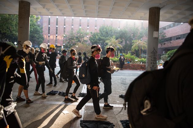 aHONG KONG, CHINA - NOVEMBER 18: Anti-government protesters walk during clashes with police at Hong Kong Polytechnic University on November 18, 2019 in Hong Kong, China. Anti-government protesters organized a general strike since Monday as demonstrations in Hong Kong stretched into its sixth month with demands for an independent inquiry into police brutality, the retraction of the word 'riot' to describe the rallies, and genuine universal suffrage. (Photo by Laurel Chor/Getty Images)
