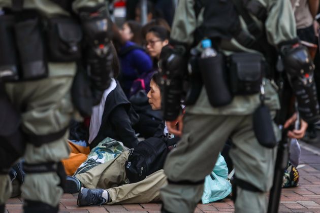 People are detained by police near the Hong Kong Polytechnic University in Hung Hom district of Hong Kong on November 18, 2019. - Pro-democracy demonstrators holed up in a Hong Kong university campus set the main entrance ablaze November 18 to prevent surrounding police moving in, after officers warned they may use live rounds if confronted by deadly weapons. (Photo by DALE DE LA REY / AFP) (Photo by DALE DE LA REY/AFP via Getty Images)