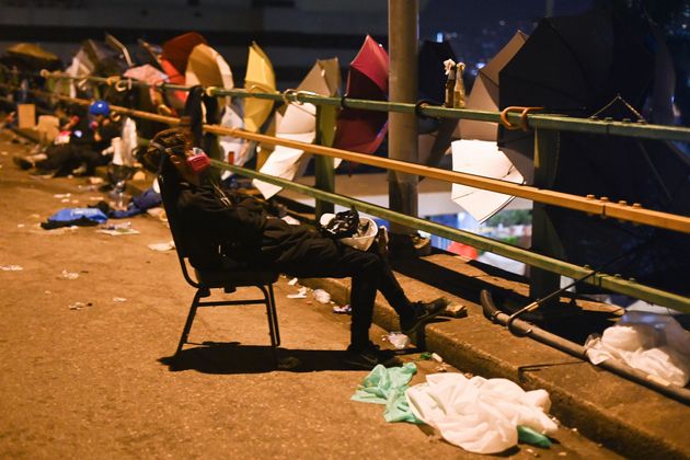 A protestor takes a rest outside the Polytechnic University of Hong Kong in Hung Hom district of Hong Kong after long clashes with police on November 18, 2019. - Hong Kong police on early November 18 warned for the first time that they may use 'live rounds' after pro-democracy protesters fired arrows and threw petrol bombs at officers at a beseiged university campus, as the crisis engulfing the city veered deeper into danger. Protests have tremored through the global financial hub since June, with many in the city of 7.5 million people venting fury at eroding freedoms under Chinese rule. (Photo by Ye Aung THU / AFP) (Photo by YE AUNG THU/AFP via Getty Images)