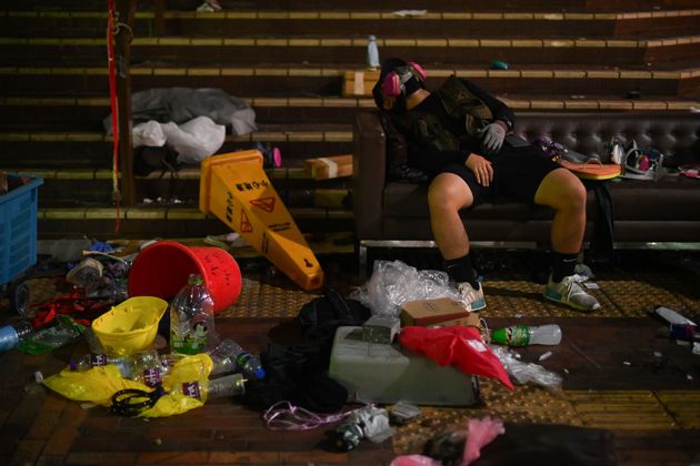 A protestor takes a rest inside the Polytechnic University of Hong Kong in Hung Hom district of Hong Kong after long clashes with police on November 18, 2019. - Hong Kong police on early November 18 warned for the first time that they may use 'live rounds' after pro-democracy protesters fired arrows and threw petrol bombs at officers at a beseiged university campus, as the crisis engulfing the city veered deeper into danger. Protests have tremored through the global financial hub since June, with many in the city of 7.5 million people venting fury at eroding freedoms under Chinese rule. (Photo by Ye Aung THU / AFP) (Photo by YE AUNG THU/AFP via Getty Images)