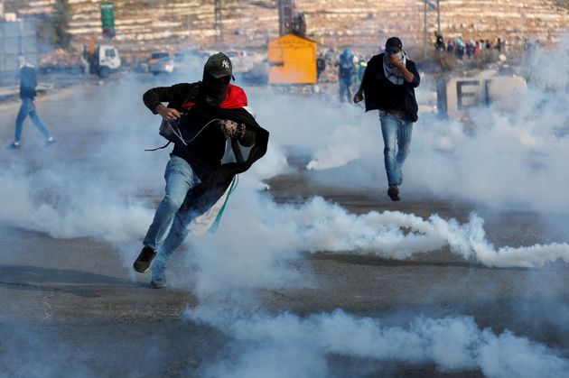 Palestinian demonstrators run away from tear gas fired by Israeli forces during an anti-Israel protest near the Jewish settlement of Beit El in the Israeli-occupied West Bank, November 16, 2019. REUTERS/Mohamad Torokman