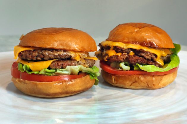 An Original Impossible Burger, left, and a Cali Burger, from Umami Burger, are shown in this photo in New York, Friday, May 3, 2019. A new era of meat alternatives is here, with Beyond Meat becoming the first vegan meat company to go public and Impossible Burger popping up on menus around the country. (AP Photo/Richard Drew)