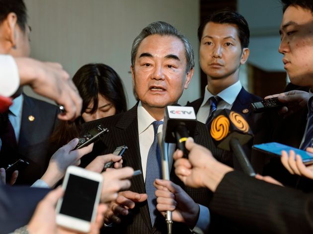 Chinese Foreign Minister Wang Yi, center, is surrounded by journalists after talks with Japanese Prime Minister Shinzo Abe at Abe's official residence in Tokyo Monday, Nov. 25, 2019. (Kimimasa Mayama/Pool Photo via AP)