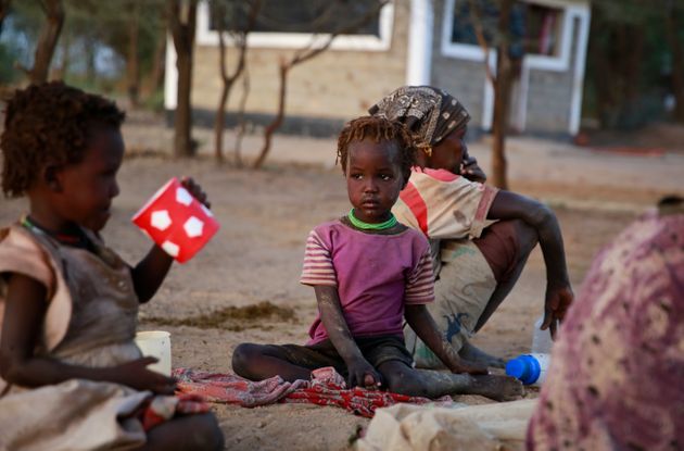 In this photo taken Sunday, March 24, 2019, Kenyan children sit down on the ground to share a meal in Nabek, Turkana county, in northern Kenya. (AP Photo/Brian Inganga)
