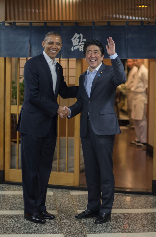 아베 신조 일본 총리와 버락 오바마 전 미국 대통령이 스키야바시 지로 앞에서 손을 흔들고 있다.
