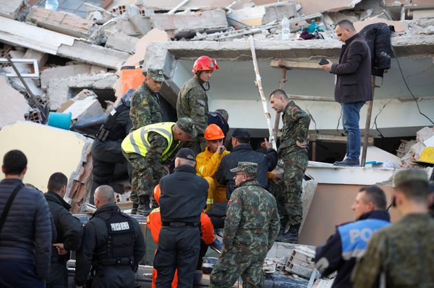 Emergency personnel talk at the site of a collapsed building in Durres, after an earthquake shook Albania, November 26, 2019. REUTERS/Florion Goga