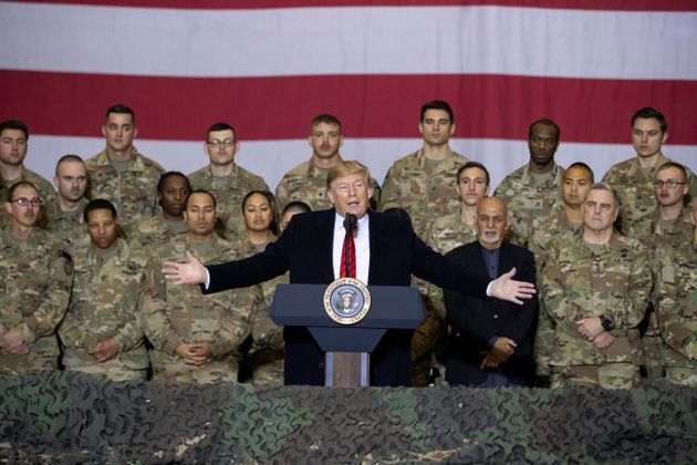 President Donald Trump, center, with Afghan President Ashraf Ghani and Joint Chiefs Chairman Gen. Mark Milley, behind him at right, while addressing members of the military during a surprise Thanksgiving Day visit, Thursday, Nov. 28, 2019, at Bagram Air Field, Afghanistan. (AP Photo/Alex Brandon)
