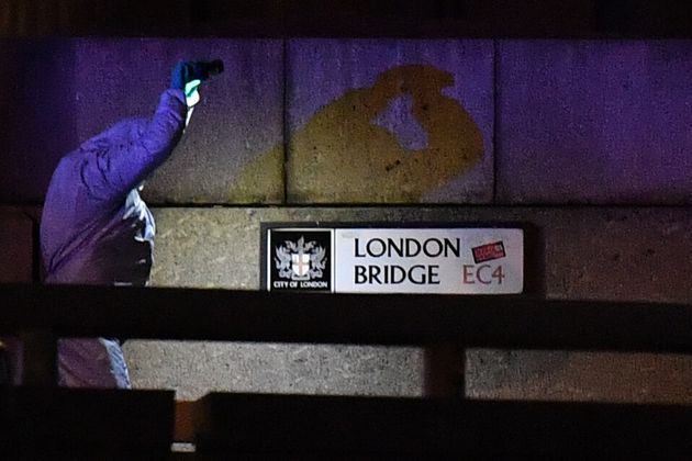 A police forensic officer lights the scene on London Bridge where armed police officers shot a suspect in central London, on November 29, 2019. - Armed police shot a man on London Bridge following a stabbing incident on Friday in which several people were believed to have been injured, reviving memories of a terror attack two years ago in which eight were killed. (Photo by Ben STANSALL / AFP) (Photo by BEN STANSALL/AFP via Getty Images)