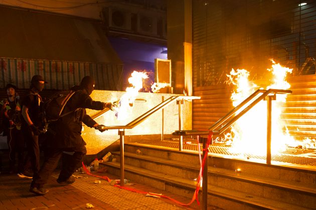 Pro-democracy protesters set fire at an entrance gate of Whampoa MTR station in Hong Kong, Sunday, Dec. 1, 2019. Thousands took to Hong Kong's streets Sunday in a new wave of pro-democracy protests, but police fired tear gas after some demonstrators hurled bricks and smokes bombs, breaking a rare pause in violence that has persisted during the six-month-long movement. (AP Photo/Ng Han Guan)