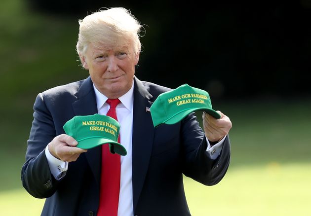 WASHINGTON, DC - AUGUST 30: U.S. President Donald Trump holds up two hats that say '<strong></div>Make Our Farmers Great Again</strong>' as he departs the White House August 30, 2018 in Washington, DC. Trump is scheduled to attend events in Indiana later today. (Photo by Win McNamee/Getty Images)