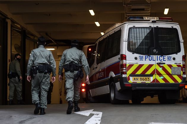 Police officers walk next to a police vehicle after a bus believed to be carrying detained protesters arrived at the West Kowloon Law Courts building in Hong Kong on November 20, 2019. - Dozens of pro-democracy protesters remained holed up inside a besieged Hong Kong university campus for a fourth straight day on November 20 as supporters took up online calls to disrupt the citys train network in a bid to distract police. (Photo by YE AUNG THU / AFP) (Photo by YE AUNG THU/AFP via Getty Images)