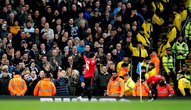 Manchester United's Fred holds an area of his back near Manchester City fans in the corner during the Premier League match at the Etihad Stadium, Manchester. (Photo by Martin Rickett/PA Images via Getty Images)