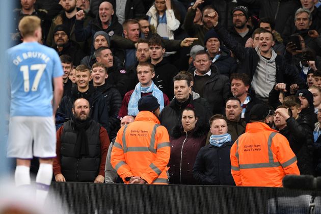 Manchester City's Belgian midfielder Kevin De Bruyne (L) tries to calm City fans jeering and throwing objects at the Manchester United players during the English Premier League football match between Manchester City and Manchester United at the Etihad Stadium in Manchester, north west England, on December 7, 2019. - Fred was hit by objects thrown from the crowd as he prepared to take a corner in the second half while footage on social media appeared to show a City fan mimicking a monkey at the Brazilian. (Photo by Oli SCARFF / AFP) / RESTRICTED TO EDITORIAL USE. No use with unauthorized audio, video, data, fixture lists, club/league logos or 'live' services. Online in-match use limited to 120 images. An additional 40 images may be used in extra time. No video emulation. Social media in-match use limited to 120 images. An additional 40 images may be used in extra time. No use in betting publications, games or single club/league/player publications. /  (Photo by OLI SCARFF/AFP via Getty Images)