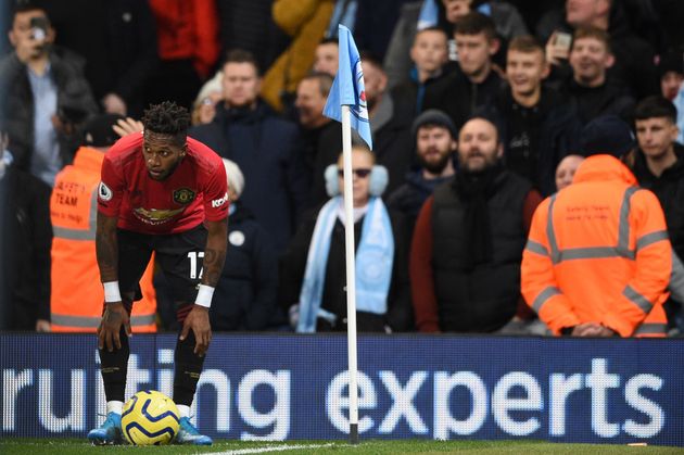 Manchester United's Brazilian midfielder Fred (L) tries to take a corner kick after being pelted with objects from the crowd during the English Premier League football match between Manchester City and Manchester United at the Etihad Stadium in Manchester, north west England, on December 7, 2019. - Fred was hit by objects thrown from the crowd as he prepared to take a corner in the second half while footage on social media appeared to show a City fan mimicking a monkey at the Brazilian. (Photo by Oli SCARFF / AFP) / RESTRICTED TO EDITORIAL USE. No use with unauthorized audio, video, data, fixture lists, club/league logos or 'live' services. Online in-match use limited to 120 images. An additional 40 images may be used in extra time. No video emulation. Social media in-match use limited to 120 images. An additional 40 images may be used in extra time. No use in betting publications, games or single club/league/player publications. /  (Photo by OLI SCARFF/AFP via Getty Images)