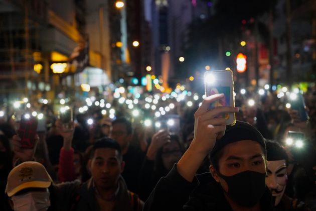 Pro-democracy protesters flash their smartphones lights as they gather on a street in Hong Kong, Sunday, Dec. 8, 2019. Thousands of people took to the streets of Hong Kong on Sunday in a march seen as a test of the enduring appeal of an anti-government movement about to mark a half year of demonstrations. (AP Photo/Vincent Yu)