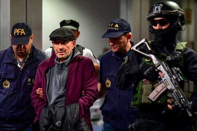Argentine former police officer Mario Sandoval (2-L) is escorted by police officers upon his arrival at Ezeiza airport in Buenos Aires on December 16, 2019, after France extradited him to face trial over the disappearance of a student. - Argentina suspects that Sandoval took part in more than 500 cases of kidnappings, torture and murder at a time when some 30,000 were 'disappeared' during the 1976-83 military dictatorship. (Photo by RONALDO SCHEMIDT / AFP) (Photo by RONALDO SCHEMIDT/AFP via Getty Images)