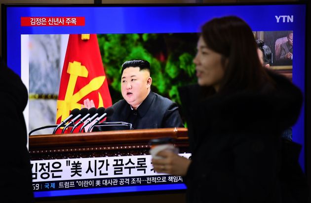 A woman walks past a television news programme showing file footage of North Korean leader Kim Jong Un, at a railway station in Seoul on January 1, 2020. - North Korean leader Kim Jong Un has declared an end to its moratoriums on nuclear and intercontinental ballistic missile tests and threatened a demonstration of a 'new strategic weapon' soon. (Photo by Jung Yeon-je / AFP) (Photo by JUNG YEON-JE/AFP via Getty Images)