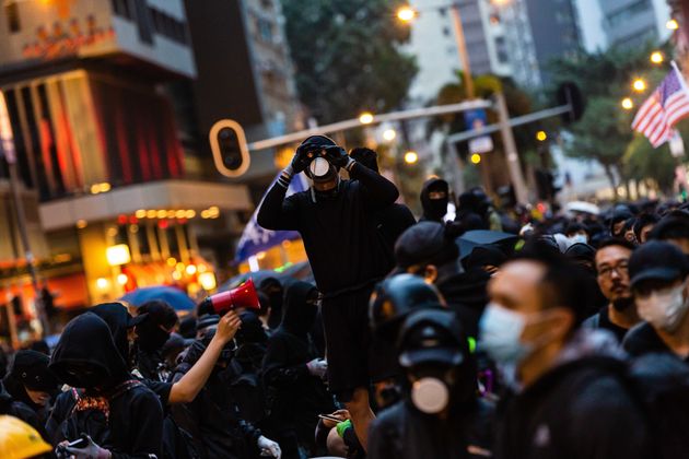 HONG KONG, CHINA - 2020/01/01: A masked protester looks out during the demonstration.
Entering the 7th month of civil unrest, protesters marched the streets, calling for the five demands to be met. Demonstrators chanted slogans and sang songs. Police in riot gear appeared and arrested several masked protesters. (Photo by Willie Siau/SOPA Images/LightRocket via Getty Images)