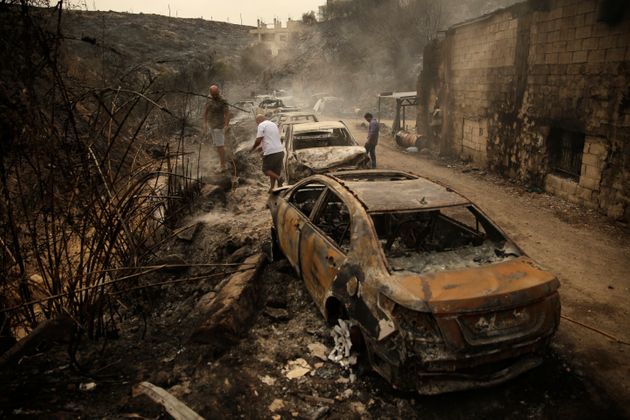베이루트 남쪽 15킬로미터 지점의 다무르 마을에서 들불에 탄 자동차와 상점을 살피고 있는 사람들. 레바논 각지에서 강한 불길이 일어, 한밤중에 집을 떠나 대피해야 하는 경우도 있었다. 2019/10/15