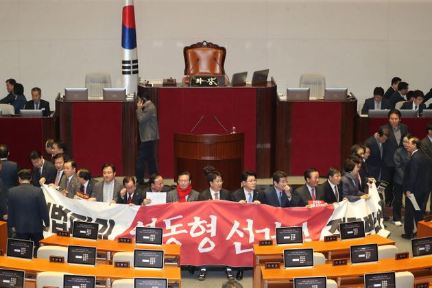 자유한국당 의원들이 지난해 12월 27일 오후 서울 여의도 국회 본회의장에서 제373회국회(임시회) 제1차 본회의에 앞서 피켓과 현수막을 들고 농성을 펼치고 있다. 