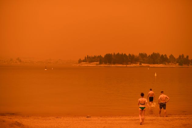 뉴사우스웨일스주 진다바인 주민들이 진다바인 호수로 들어가고 있다. 들불 연기로 인해 하늘이 빨갛다. 1월 4일.