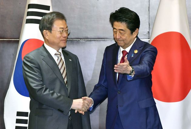 Japan's Prime Minister Shinzo Abe shakes hands with South Korea's President Moon Jae-in during their meeting in Chengdu, China, December 24, 2019, in this photo released by Kyodo. Mandatory credit Kyodo/via REUTERS ATTENTION EDITORS - THIS IMAGE WAS PROVIDED BY A THIRD PARTY. MANDATORY CREDIT. JAPAN OUT. NO COMMERCIAL OR EDITORIAL SALES IN JAPAN.