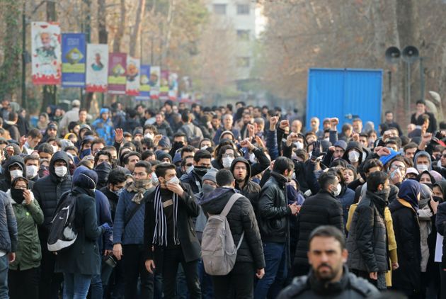 Iranian students gather for a demonstration over the downing of a Ukrainian airliner at Tehran University on January 14, 2020. - AFP correspondents said around 200 mainly masked students gathered at Tehran University and were locked in a tense standoff with youths from the Basij militia loyal to the establishment.'Death to Britain,' women clad in black chadours chanted as Basij members burned a cardboard cutout of the British ambassador to Tehran, Rob Macaire, after his brief arrest for allegedly attending a demonstration Saturday. Kept apart by security forces, the groups eventually parted ways. (Photo by ATTA KENARE / AFP) (Photo by ATTA KENARE/AFP via Getty Images)