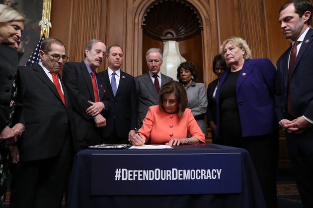 WASHINGTON, DC - JANUARY 15: U.S. Speaker of the House Nancy Pelosi (D-CA) (C) signs the articles of impeachment against President Donald Trump during an engrossment ceremony with Rep. Carolyn Maloney (D-NY), Rep. Jerrold Nadler (D-NY), Rep. Eliot Engle (D-NY), Rep. Adam Schiff (D-CA), Rep. Richard Neal (D-MA), Rep. Maxine Waters (D-CA), Rep. Val Demings (D-FL), Rep. Zoe Lofgren (D-CA) and Rep. Jason Crow (D-CO) in the Rayburn Room at the U.S. Capitol January 15, 2020 in Washington, DC. The House of Representatives voted to approve the managers and send the articles of impeachment to the Senate, where Majority Leader Mitch McConnell (R-KY) said the trial will begin next Tuesday. (Photo by Chip Somodevilla/Getty Images)