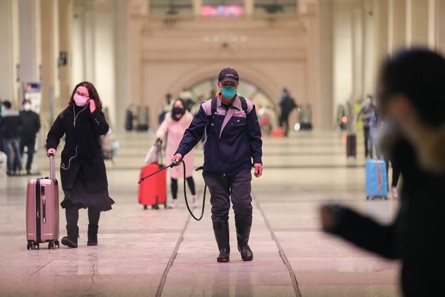 A staff member (C) disinfects at the Hankou Railway Station in Wuhan, in China's central Hubei province early on January 22, 2020. - The Chinese city at the centre of a SARS-like virus outbreak has urged people to stay away, cancelling a major Lunar New Year event, as it strives to contain a disease that has spread across the country. (Photo by STR / AFP) / China OUT (Photo by STR/AFP via Getty Images)
