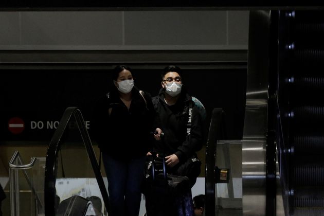 Travellers wearing masks arrive on a direct flight from China, after a spokesman from the U.S. Centers for Disease Control and Prevention (CDC) said a traveller from China had been the first person in the United States to be diagnosed with the Wuhan coronavirus, at Seattle-Tacoma International Airport in SeaTac, Washington, U.S. January 23, 2020.  REUTERS/David Ryder