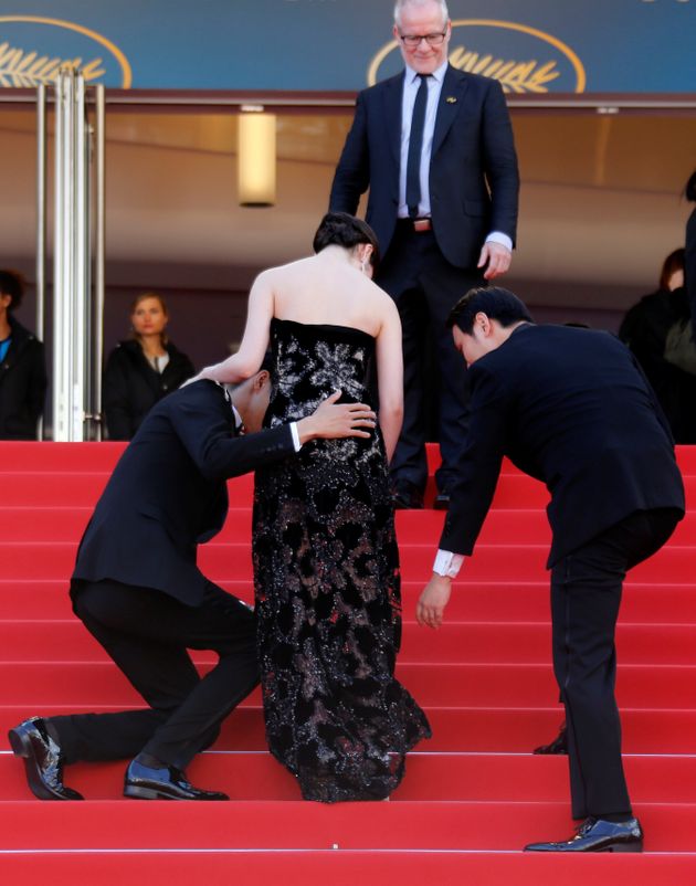 71st Cannes Film Festival - Screening of the film Asako I & II (Netemo sametemo) in competition - Red Carpet Arrivals - Cannes, France, May 14, 2018. Director Ryusuke Hamaguchi and cast member Masahiro Higashide help cast member Erika Karata as Cannes Film Festival general delegate Thierry Fremaux is seen in the background. REUTERS/Regis Duvignau