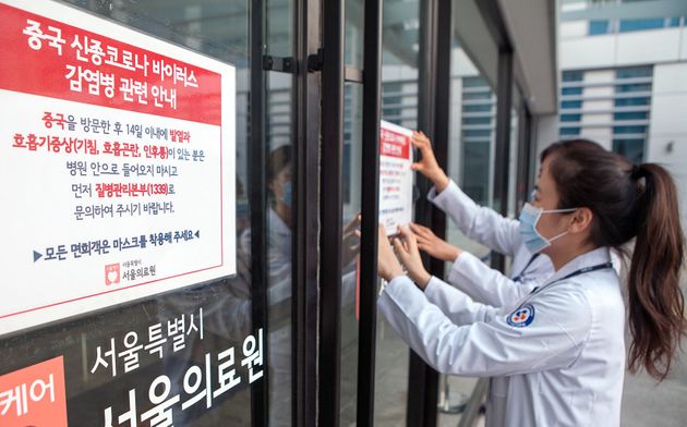 서울의료원 의료진이 감염 예방 강화를 위해 의료원 내외부에 관련 안내문을 부착하고 있는 모습