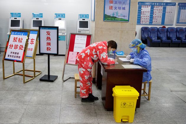 A woman signs in at the reception area of the First People's Hospital in Yueyang, Hunan Province, near the border to Hubei Province, which is under partial lockdown after an outbreak of a new coronavirus, in China January 28, 2020.  REUTERS/Thomas Peter