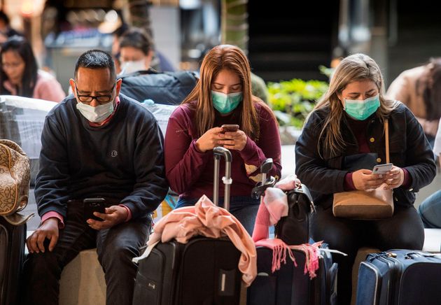 Passengers wear face masks to protect against the spread of the Coronavirus as they arrive on a flight from Asia at Los Angeles International Airport, California, on January 29, 2020. (Photo by Mark RALSTON / AFP) (Photo by MARK RALSTON/AFP via Getty Images)
