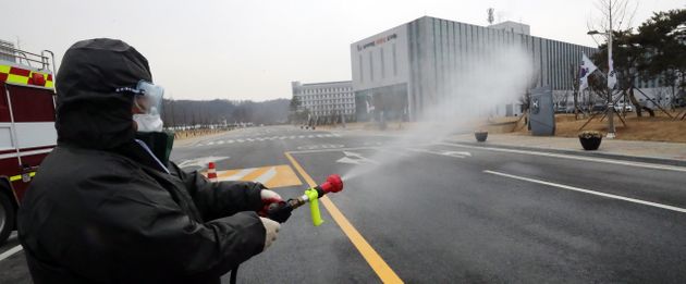 31일 충북 진천군 국가공무원인재개발원에서 방역담당 직원이 출입차량용 소독약품을 뿌리고 있다.  
