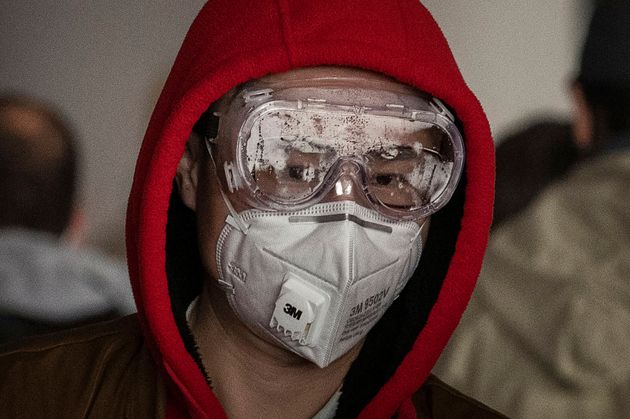 BEIJING, CHINA - JANUARY 30: A man wears a protective mask and goggles as he lines up to check in to a flight at Beijing Capital Airport on January 30, 2020 in Beijing, China. (Photo by Kevin Frayer/Getty Images)