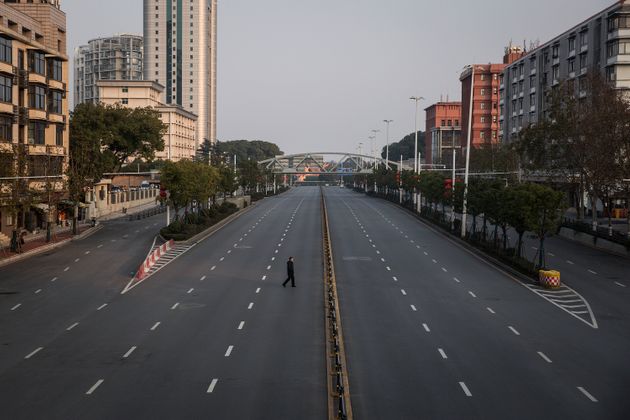 A man cross an empty highway road on February 3, 2020 in Wuhan, Hubei province, China. 