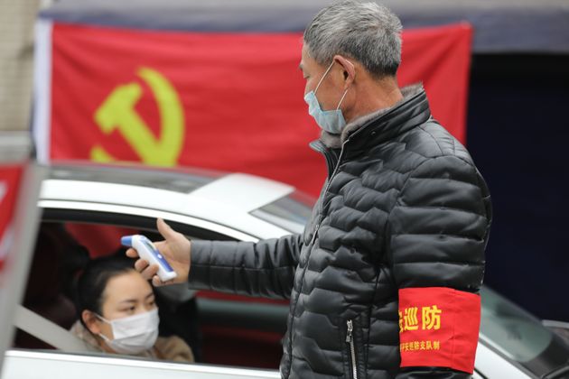 HANGZHOU, CHINA - FEBRUARY 03 2020: A volunteer checks the temperature of passers-by at a checkpoint in Hangzhou in east China's Zhejiang province Monday, Feb. 03, 2020.- PHOTOGRAPH BY Feature China / Barcroft Media (Photo credit should read Feature China/Barcroft Media via Getty Images)