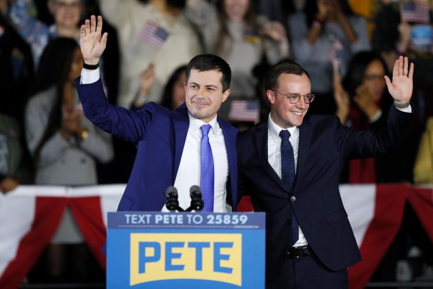Democratic presidential candidate former South Bend, Ind., Mayor Pete Buttigieg and his husband Chasten, right, wave to supporters at a caucus night campaign rally, Monday, Feb. 3, 2020, in Des Moines, Iowa. (AP Photo/Charlie Neibergall)