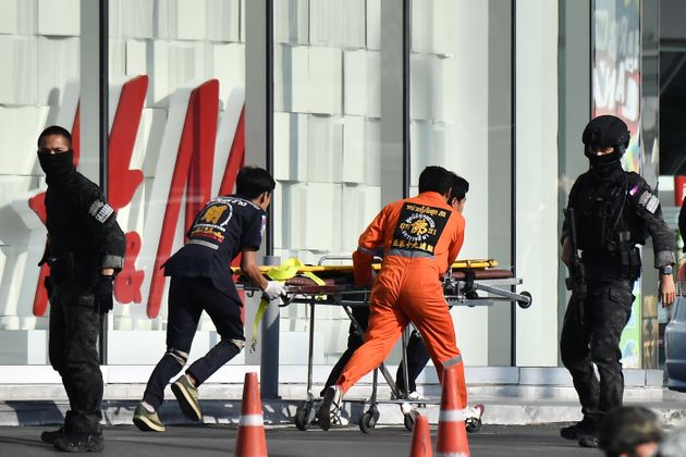 Medical personnel (in orange) prepare to enter the Terminal 21 mall, where a mass shooting took place and the gunman is currently still hiding, to help injured people remaining in the mall in the Thai northeastern city of Nakhon Ratchasima on February 9, 2020. - A Thai soldier who killed 21 people in a shooting spree remained holed up in shopping mall on the morning of February 9 with an unknown number of people feared trapped inside, despite repeated attempts by armed police to flush the gunman out. (Photo by Lillian SUWANRUMPHA / AFP) (Photo by LILLIAN SUWANRUMPHA/AFP via Getty Images)