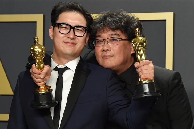 Han Jin Won, left, and Bong Joon Ho, winners of the award for best original screenplay for 'Parasite', pose in the press room at the Oscars on Sunday, Feb. 9, 2020, at the Dolby Theatre in Los Angeles. (Photo by Jordan Strauss/Invision/AP)