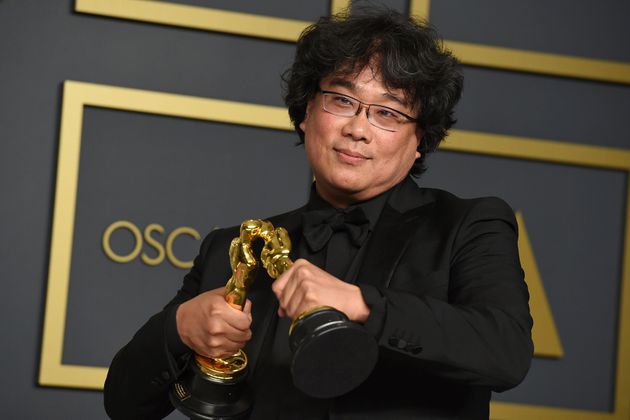 Bong Joon Ho poses in the press room with the awards for best director for 'Parasite' and for best international feature film for 'Parasite' from South Korea at the Oscars on Sunday, Feb. 9, 2020, at the Dolby Theatre in Los Angeles. (Photo by Jordan Strauss/Invision/AP)